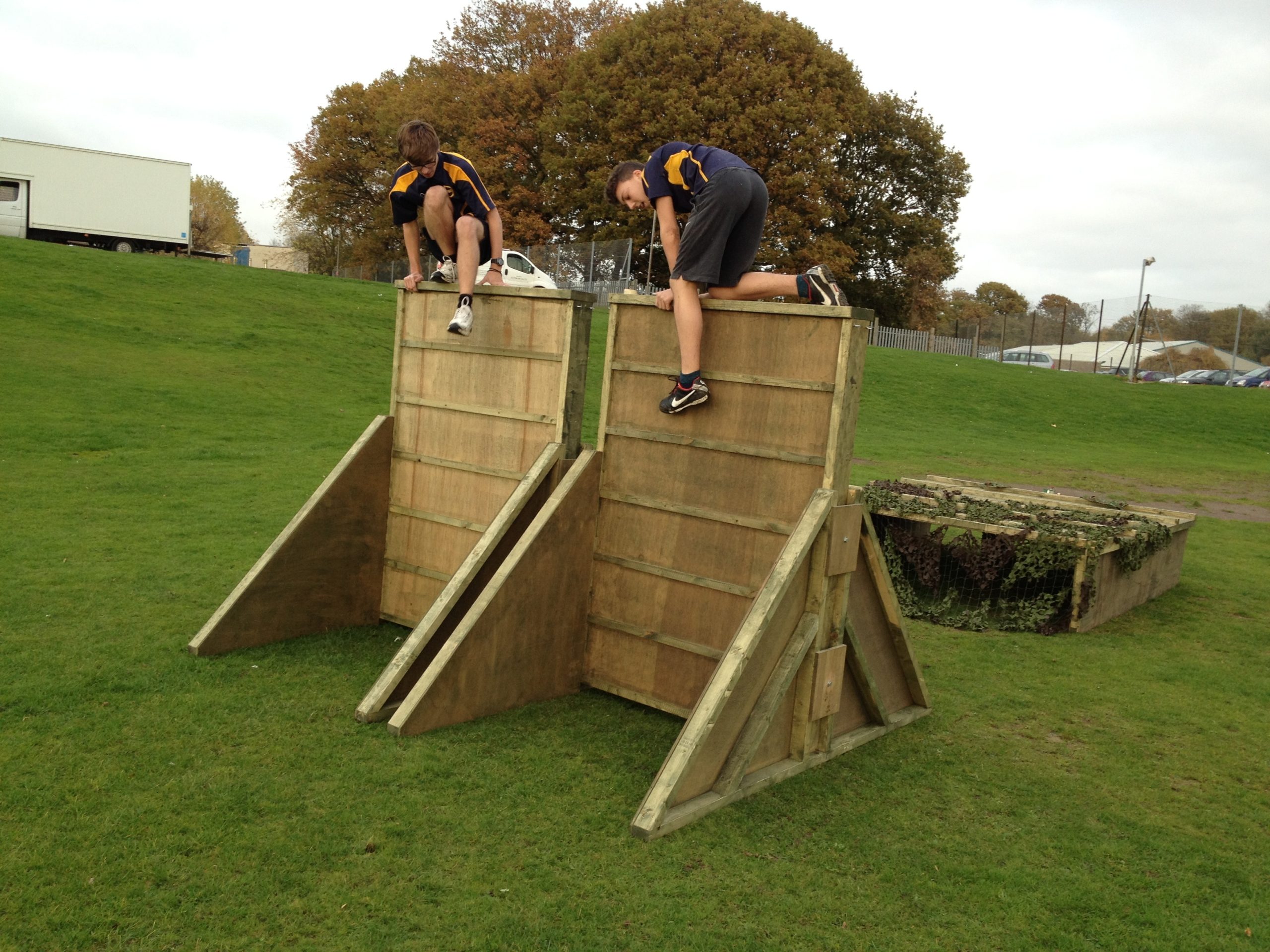 Children Climbing Over Obstacle Course Wall