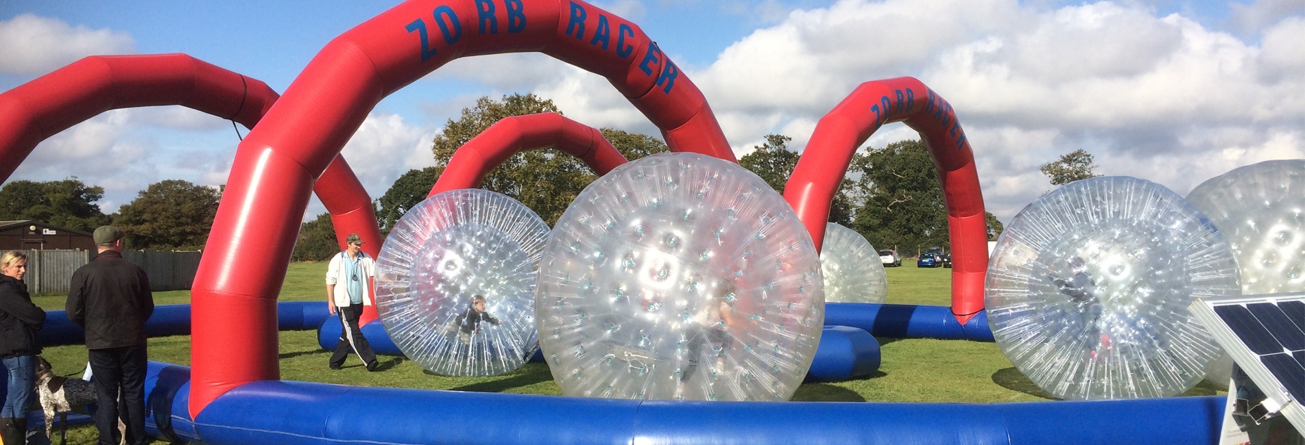 People Taking Part In Zorb Racing