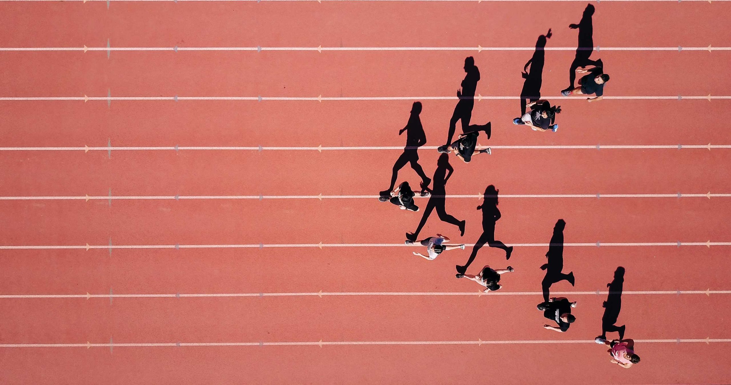 people running on a track from a birds eye view